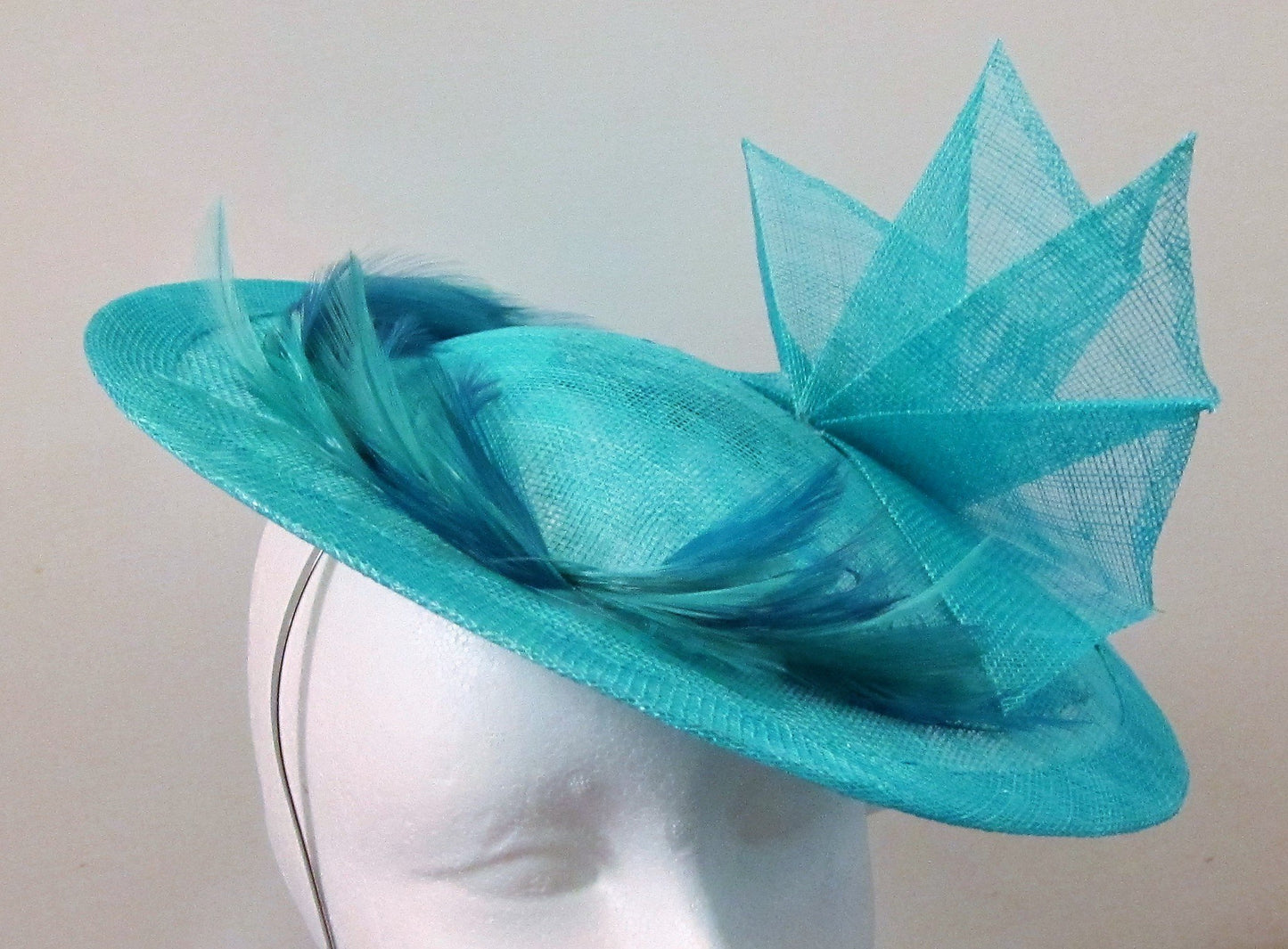 Handcrafted turquoise disk with fan and feathers fascinator on a headband