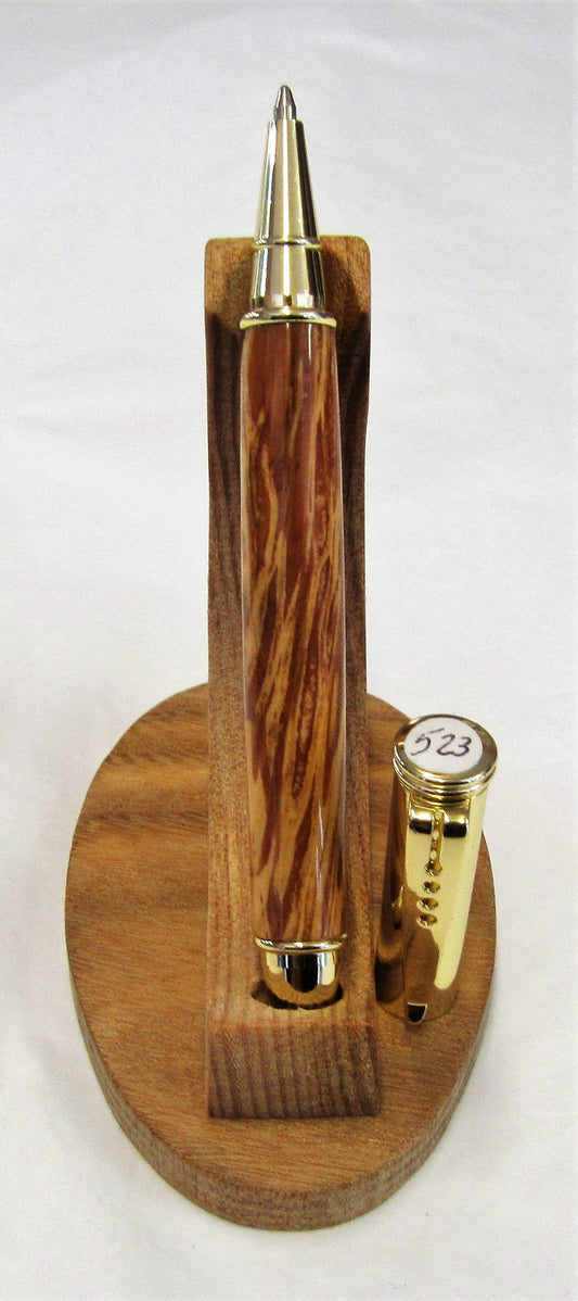 Handcrafted American red oak pen with various fittings and pen types.
