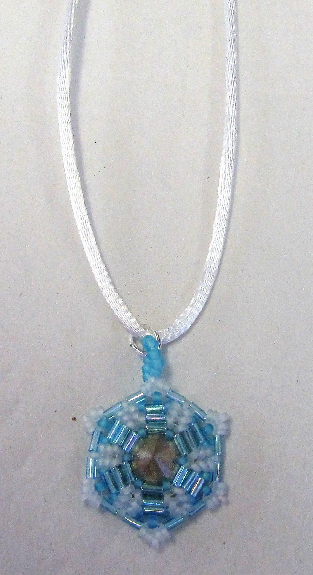 Handcrafted blue beaded pendant on white cord necklace