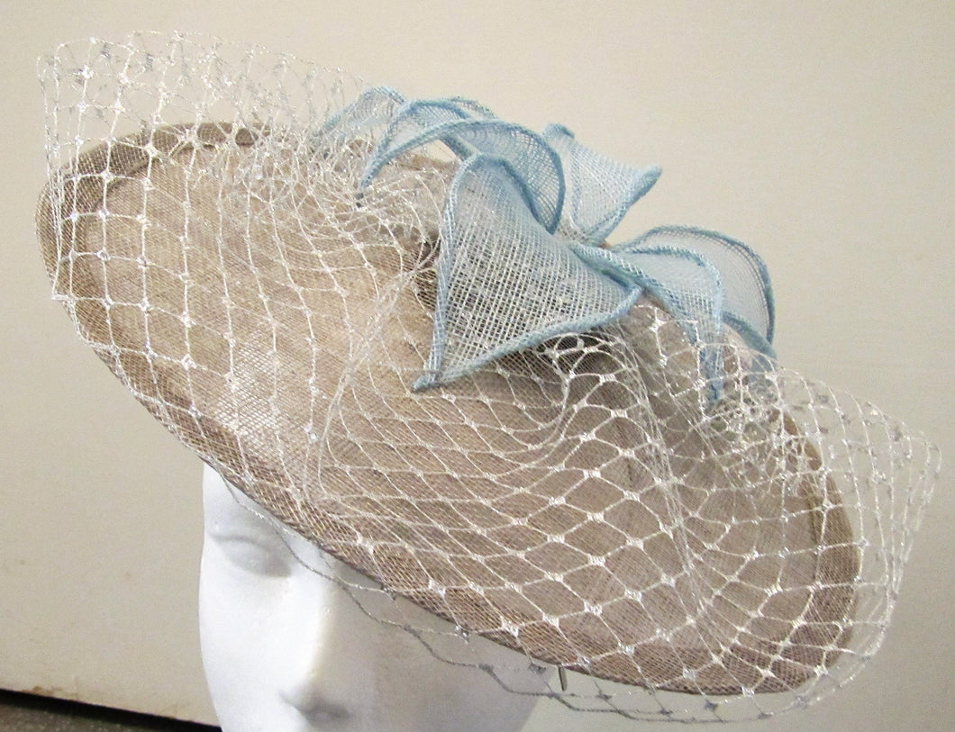 Handcrafted pewter disk fascinator with silver netting and blue leaves on a hair band