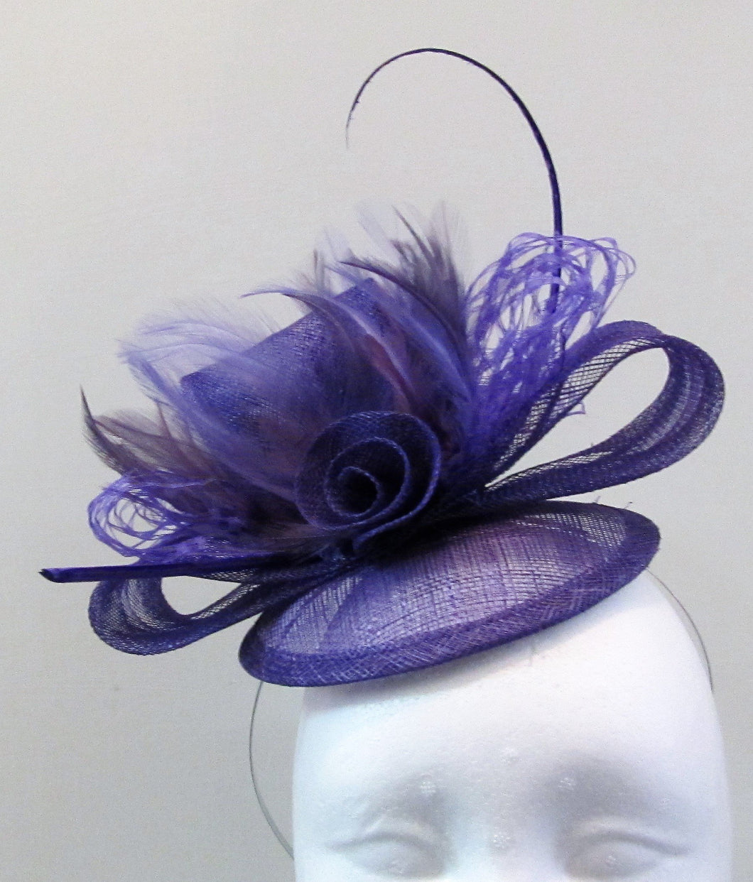 Handcrafted purple fascinator with bow, a flower and purple feathers on a hair band or hair clip