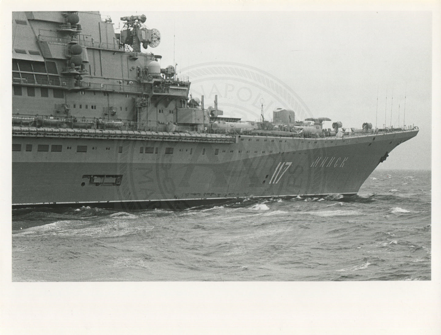 Official U.S. Navy photo of Soviet Kiev class aircraft carrier Minsk underway with an aircraft hovering above the deck.