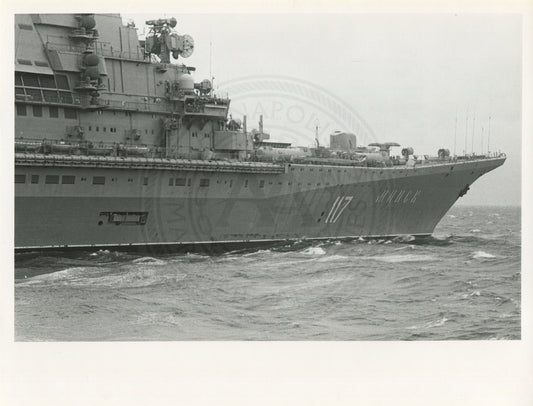 Official U.S. Navy photo of Soviet Kiev class aircraft carrier Minsk underway with an aircraft hovering above the deck.