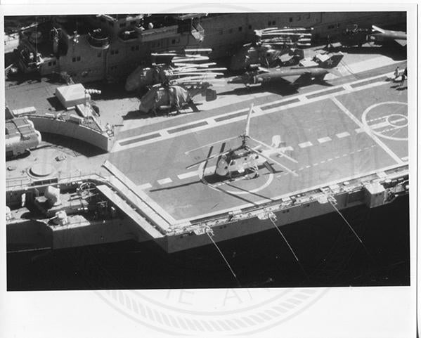 Official U.S. Navy photo of Soviet Kiev class aircraft carrier Minsk underway with an aircraft hovering above the deck.